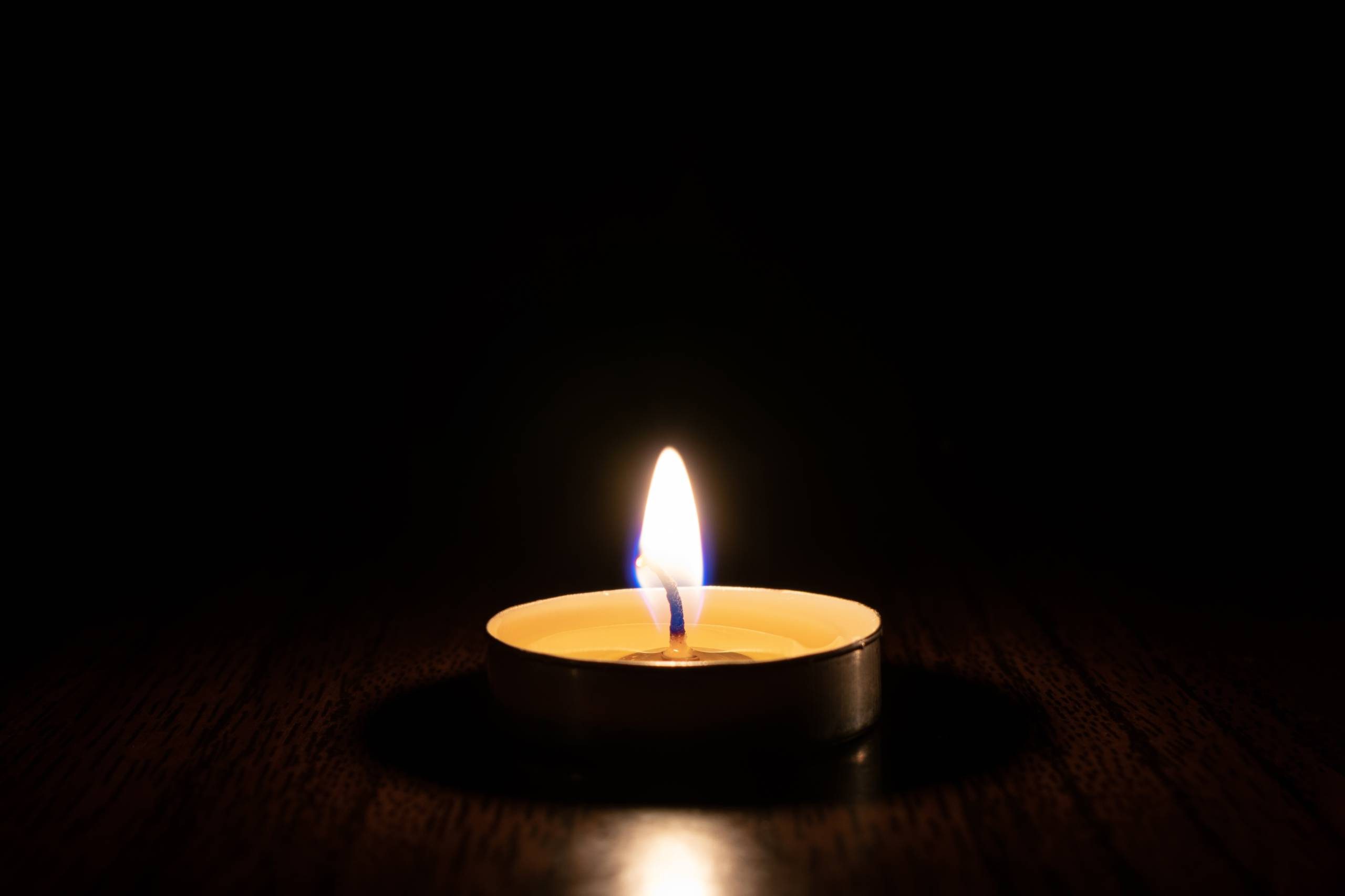 A photo of a candle lit in complete darkness.