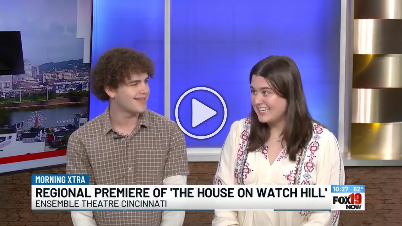 Two people sit side by side on a TV news set. A blue banner reads, Regional Premiere of The House on Watch Hill Ensemble Theatre Cincinnati, with the FOX19 NOW logo and temperature displayed in the lower right corner.